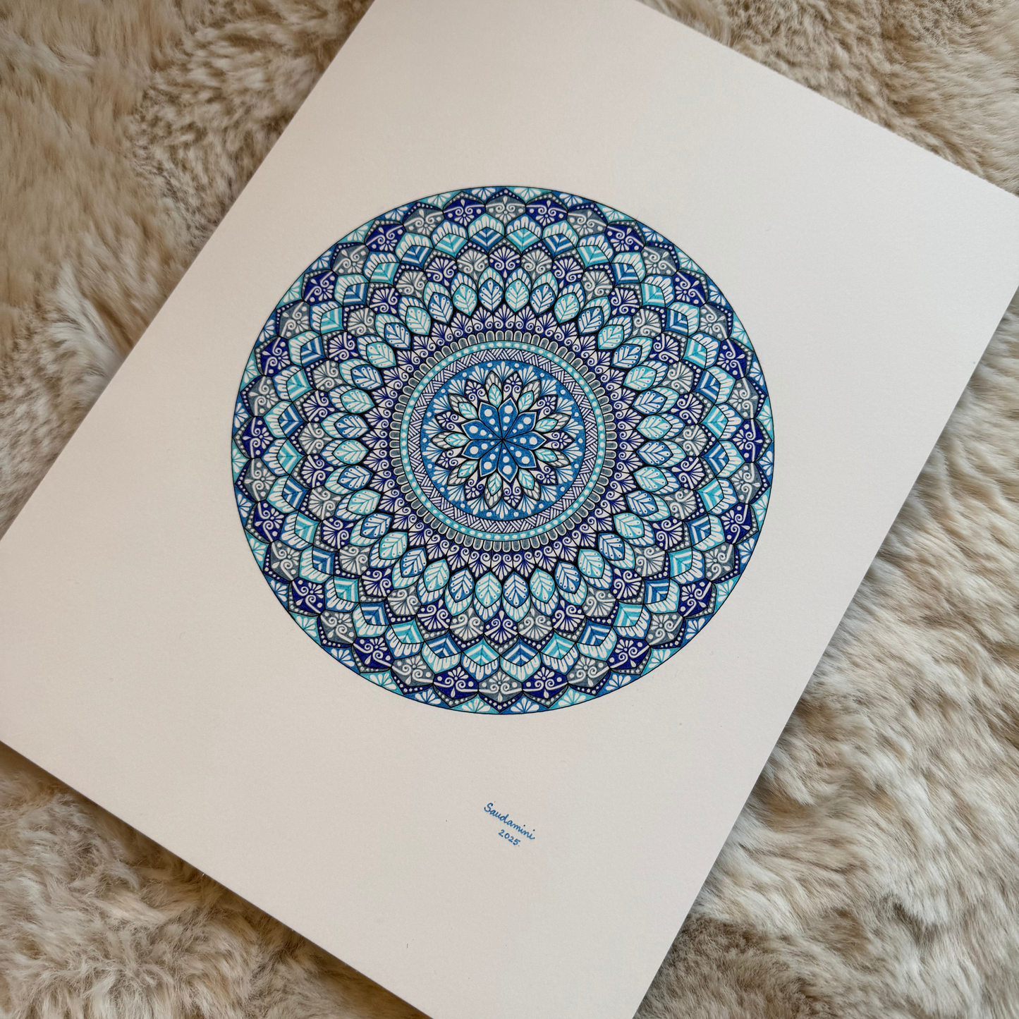 Mandala artwork with blue and green patterns on a white background