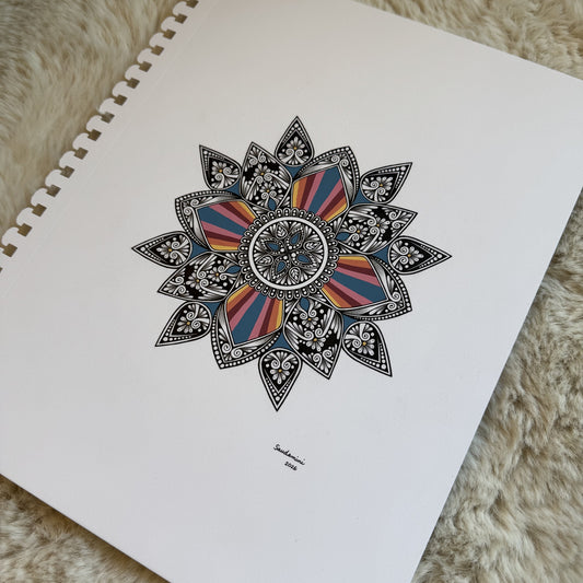 Hand-drawn colorful mandala by Saudamini Madra in ink on Bristol paper, photographed on textured surface