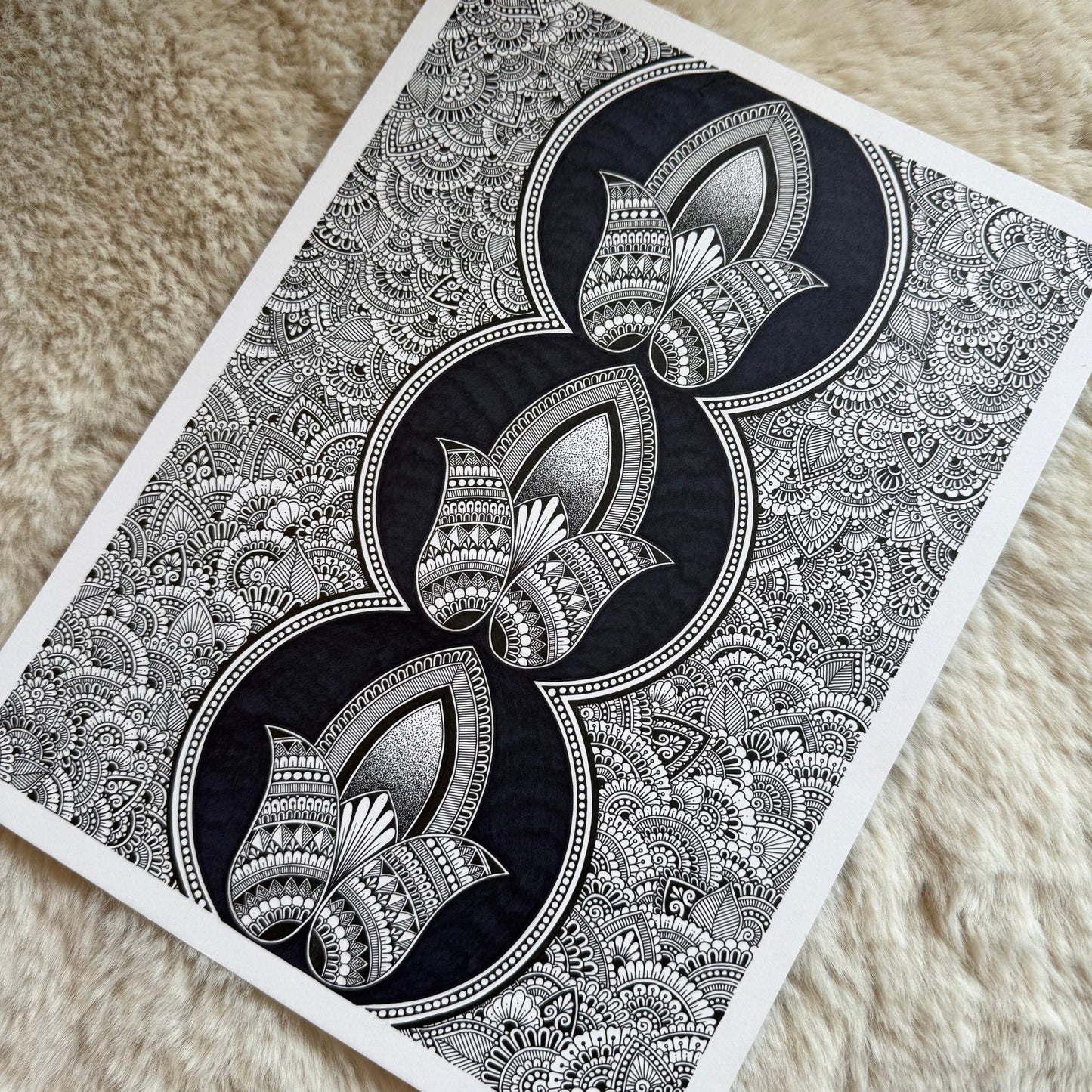 Hand-drawn zentangle by Saudamini Madra, three stacked lotus forms in black ink on Bristol paper, detail view