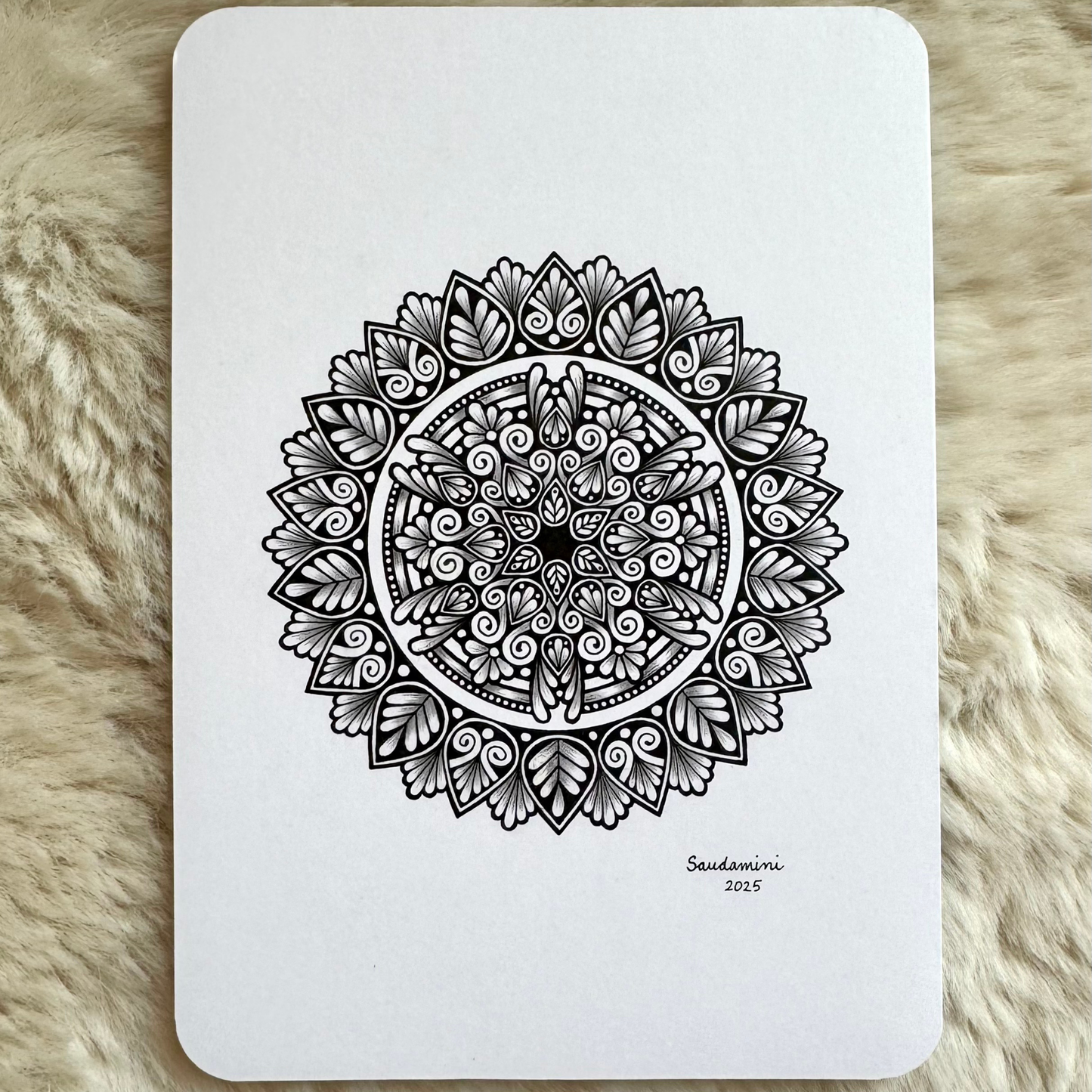 Black mandala artwork on a textured surface