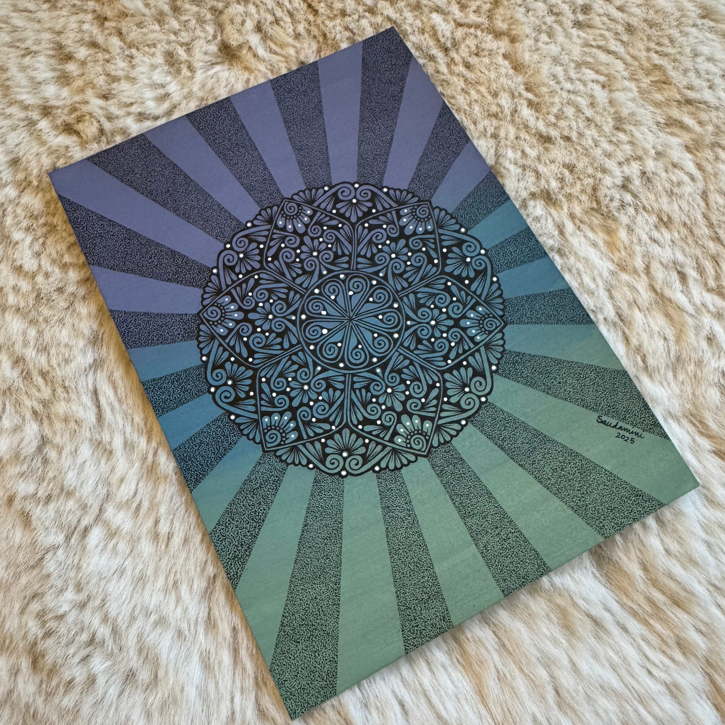 Decorative notebook with mandala design on a textured surface