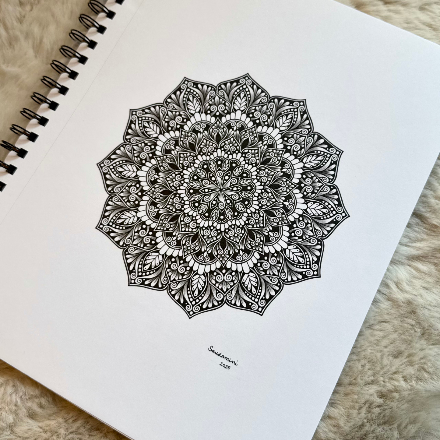 Mandala drawing on a notebook page with a textured surface background