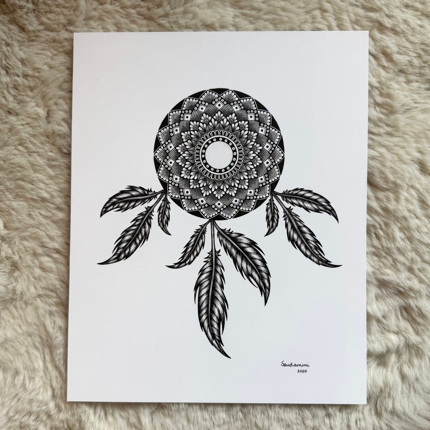 Hand-drawn dreamcatcher mandala by Saudamini Madra showing detailed feather rendering in black ink on Bristol paper