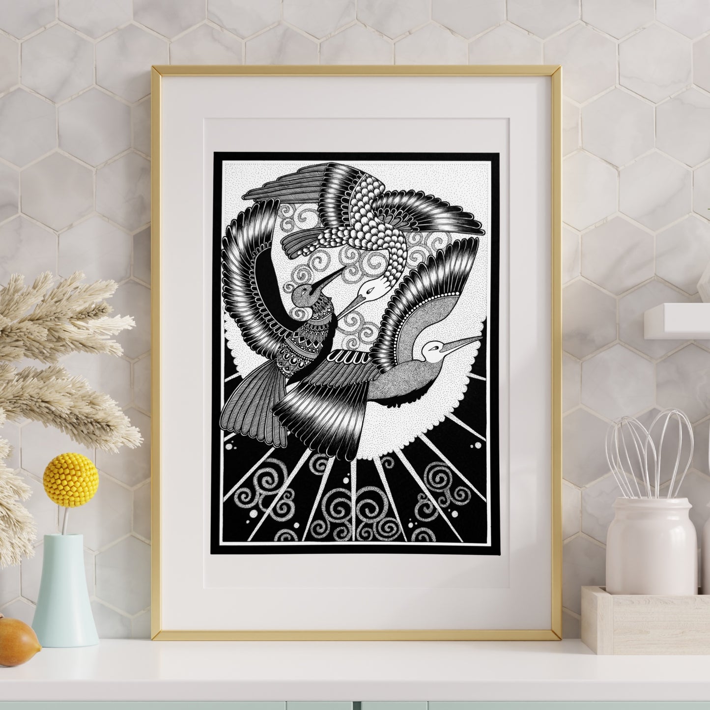 Composite mockup of A Covenant of Wings Zentangle by Saudamini Madra, two birds in flight in black ink on Bristol paper, shown in a gold frame on a marble-tiled wall
