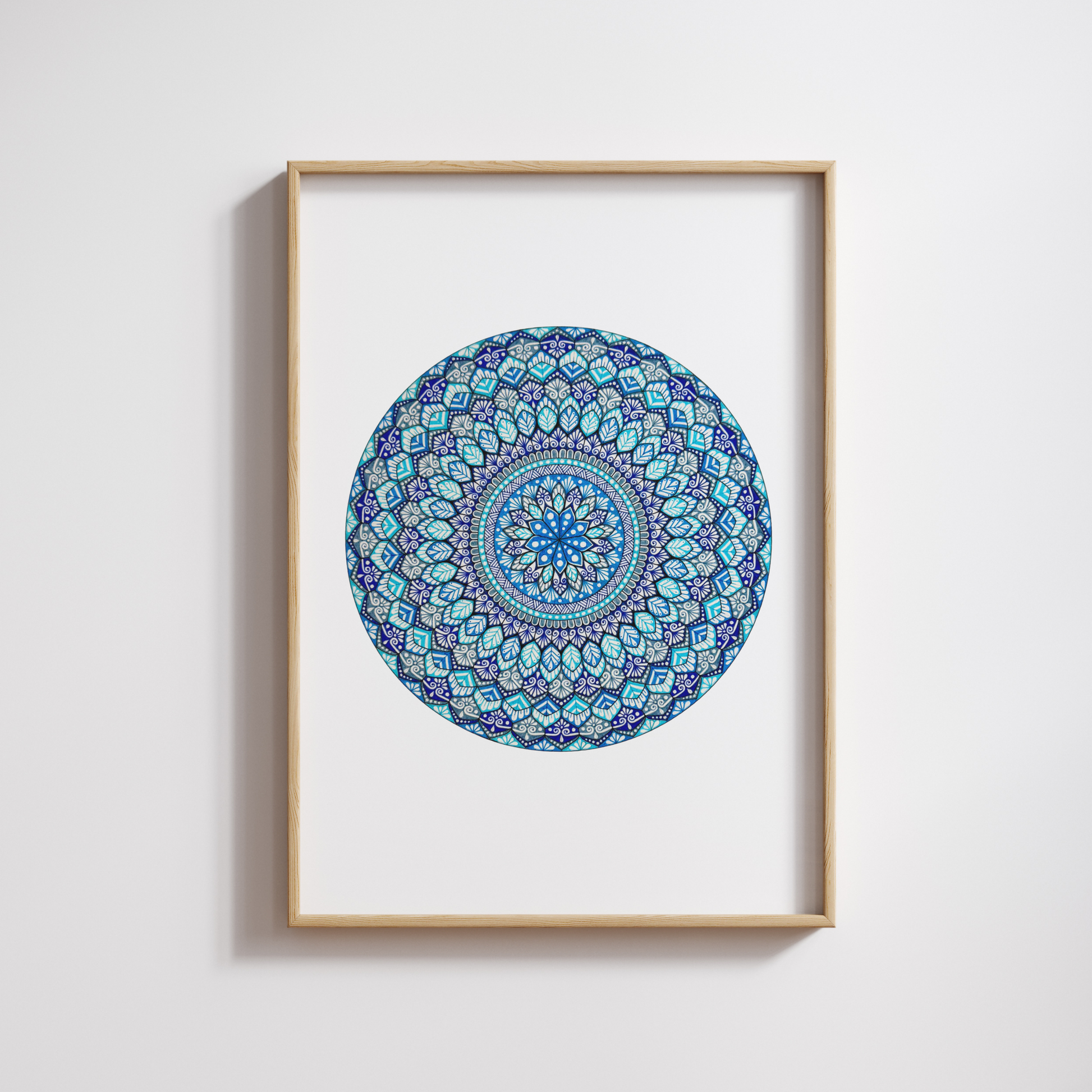 Mandala artwork with blue and green patterns on a white background