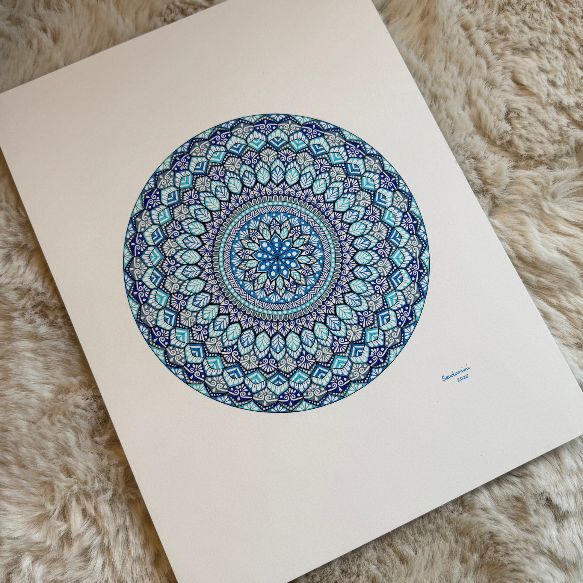 Mandala artwork with blue and green patterns on a white background