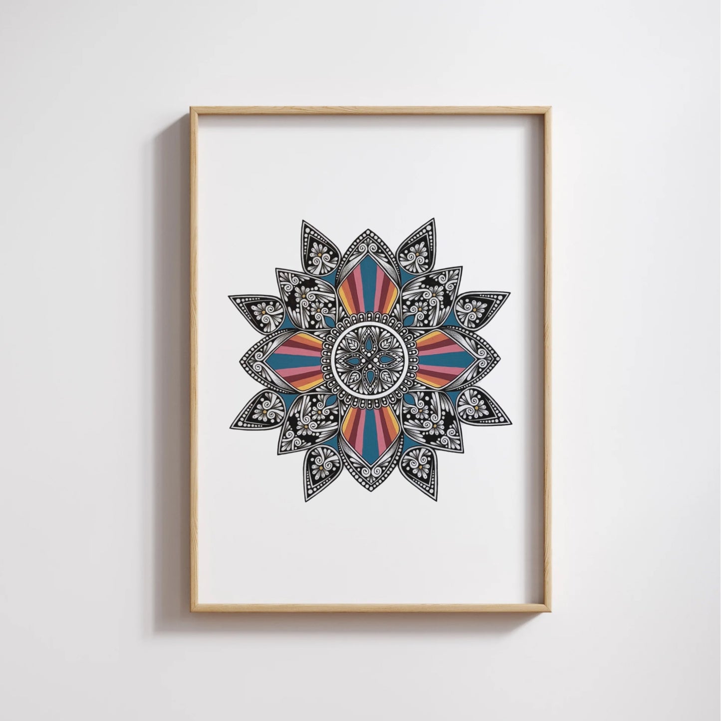 Composite mockup of A Promise Lit From Within Mandala by Saudamini Madra, a hand-drawn colorful mandala in ink on Bristol paper, shown in a wood frame on a white wall