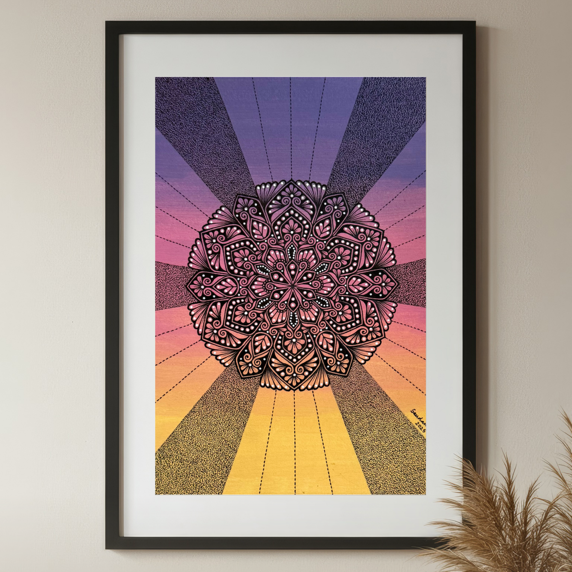 Framed mandala art with a colorful radial design on a beige wall.