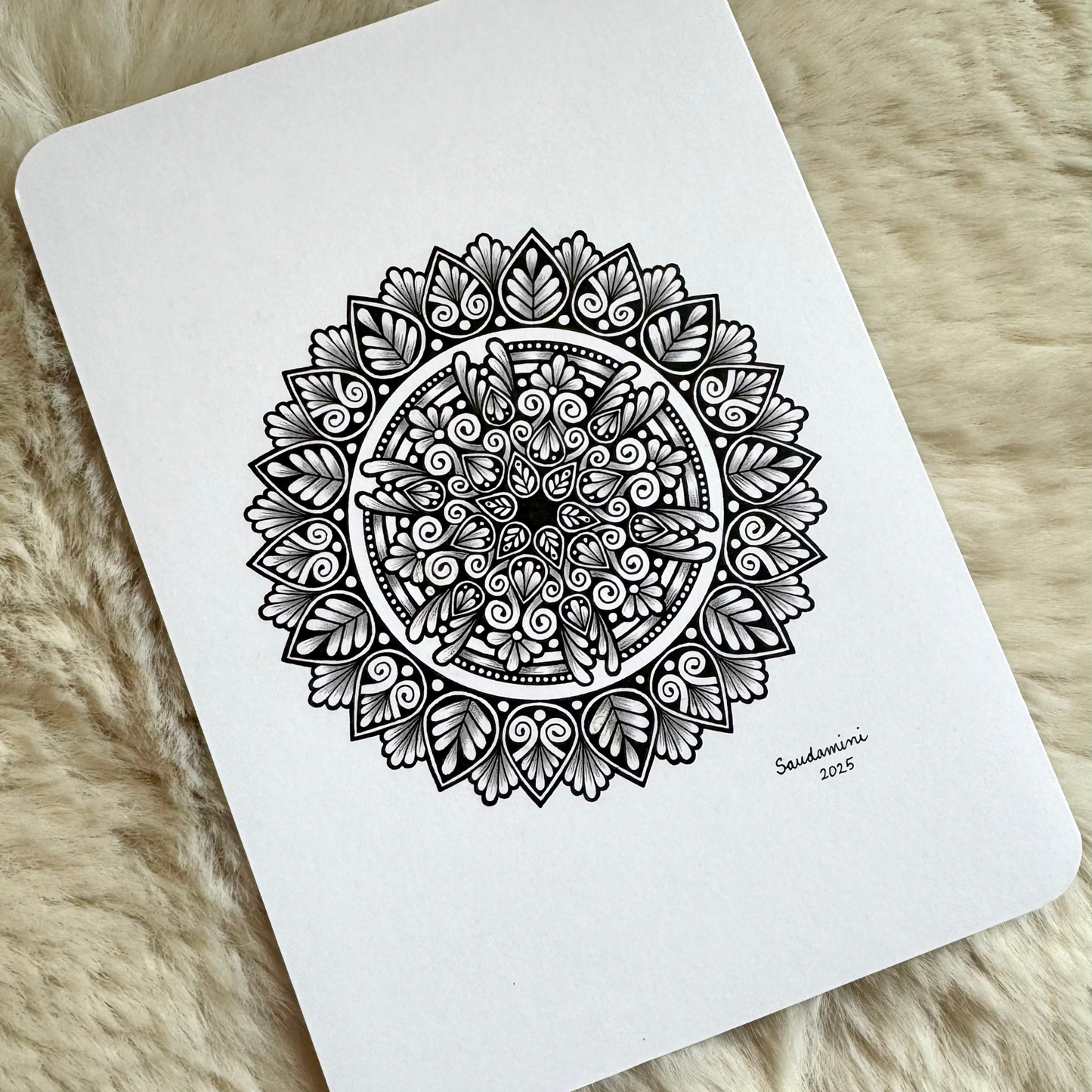 Black mandala artwork on a textured surface