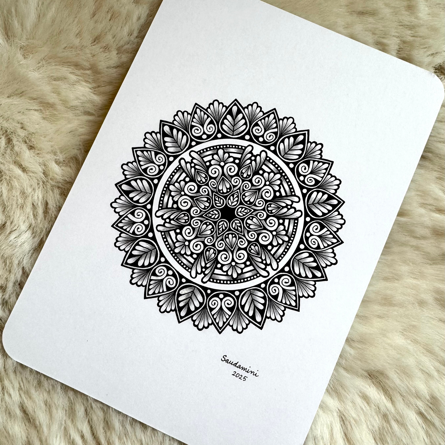 Black mandala artwork on a textured surface