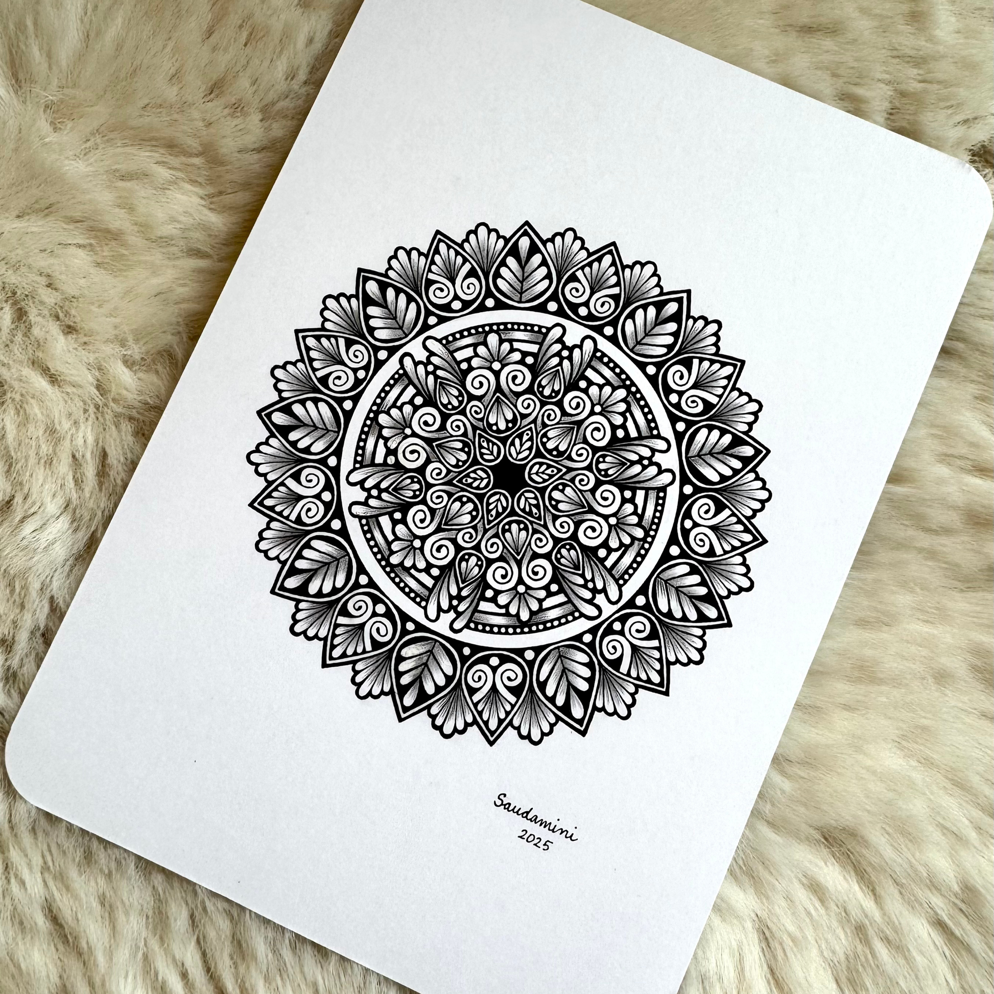 Black mandala artwork on a textured surface