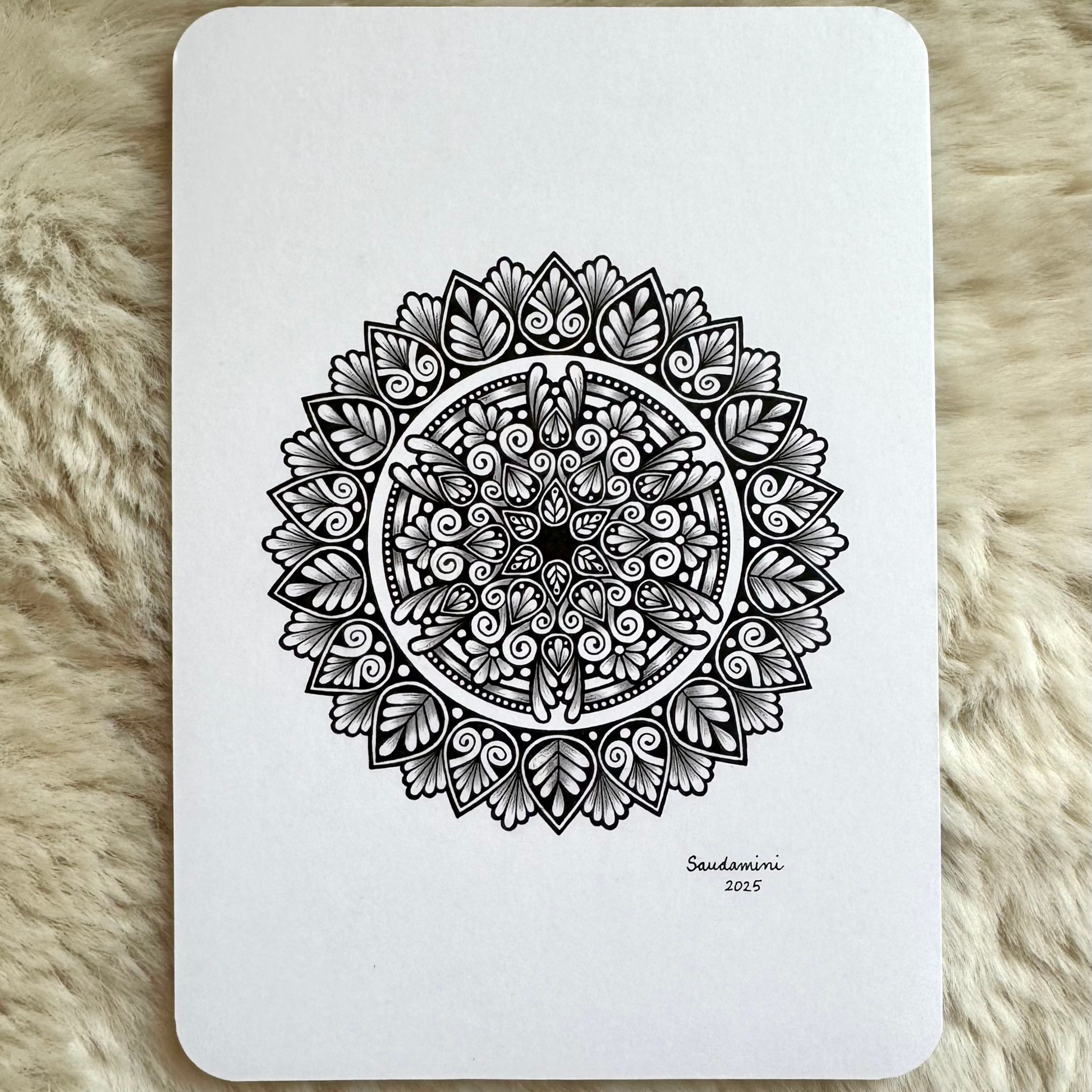 Black mandala artwork on a textured surface