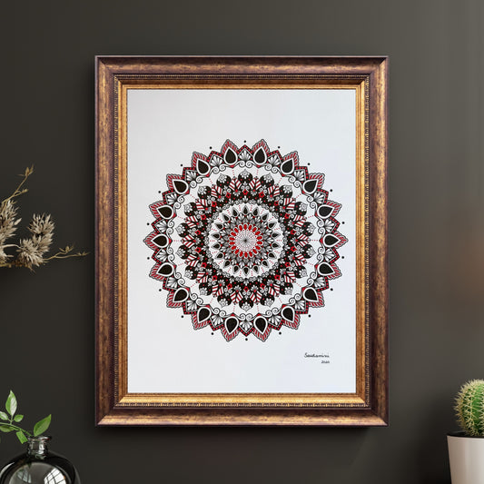 Composite mockup of What the Flame Left Behind Mandala by Saudamini Madra, a mandala in black and red ink on Bristol paper, shown in an ornate gold frame on a dark wall
