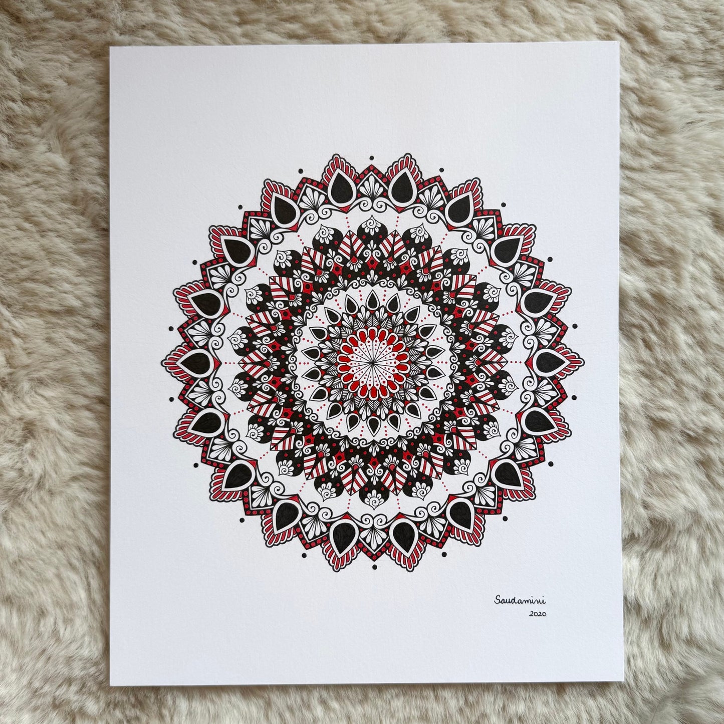 Hand-drawn mandala by Saudamini Madra showing fine red and black ink patterning on Bristol paper