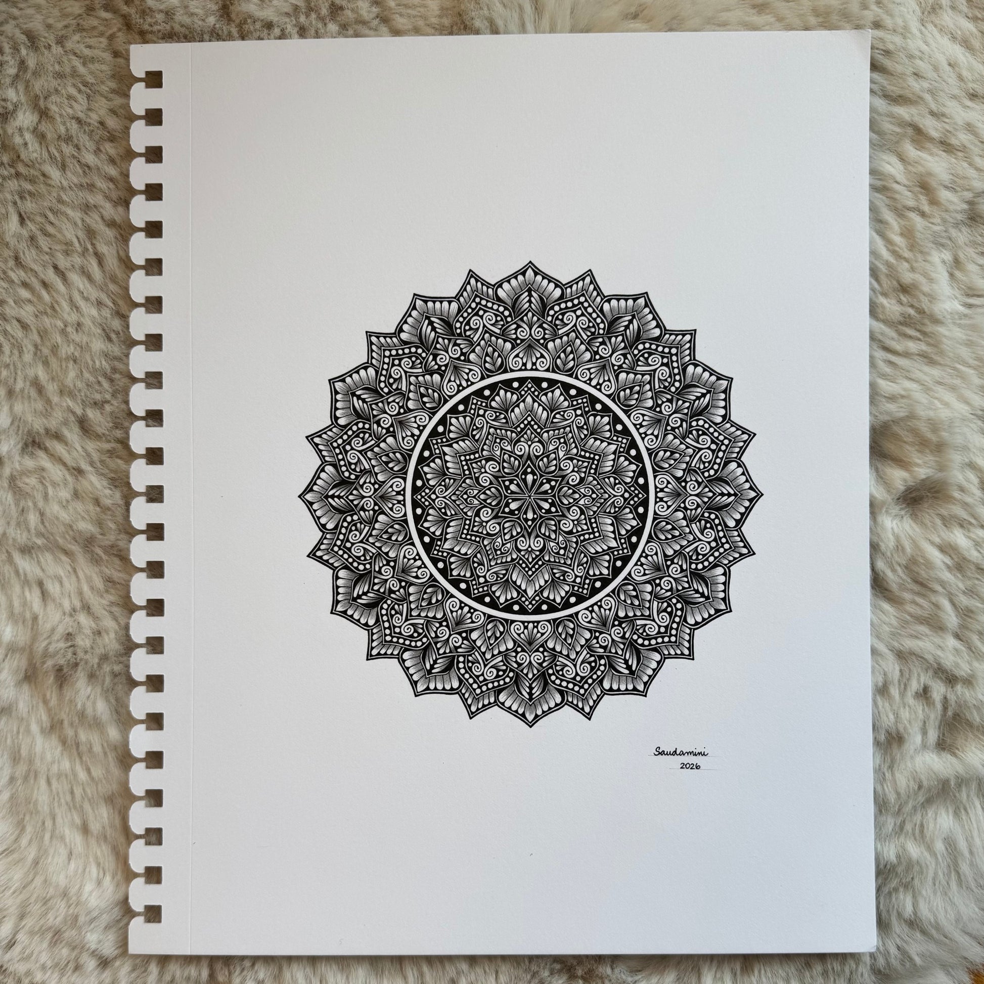Hand-drawn mandala by Saudamini Madra showing fine black ink patterning on Bristol paper