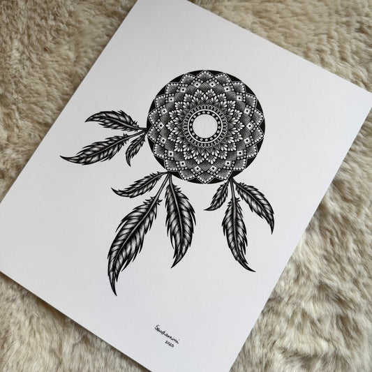 Hand-drawn dreamcatcher mandala by Saudamini Madra in black ink on Bristol paper, photographed on textured surface