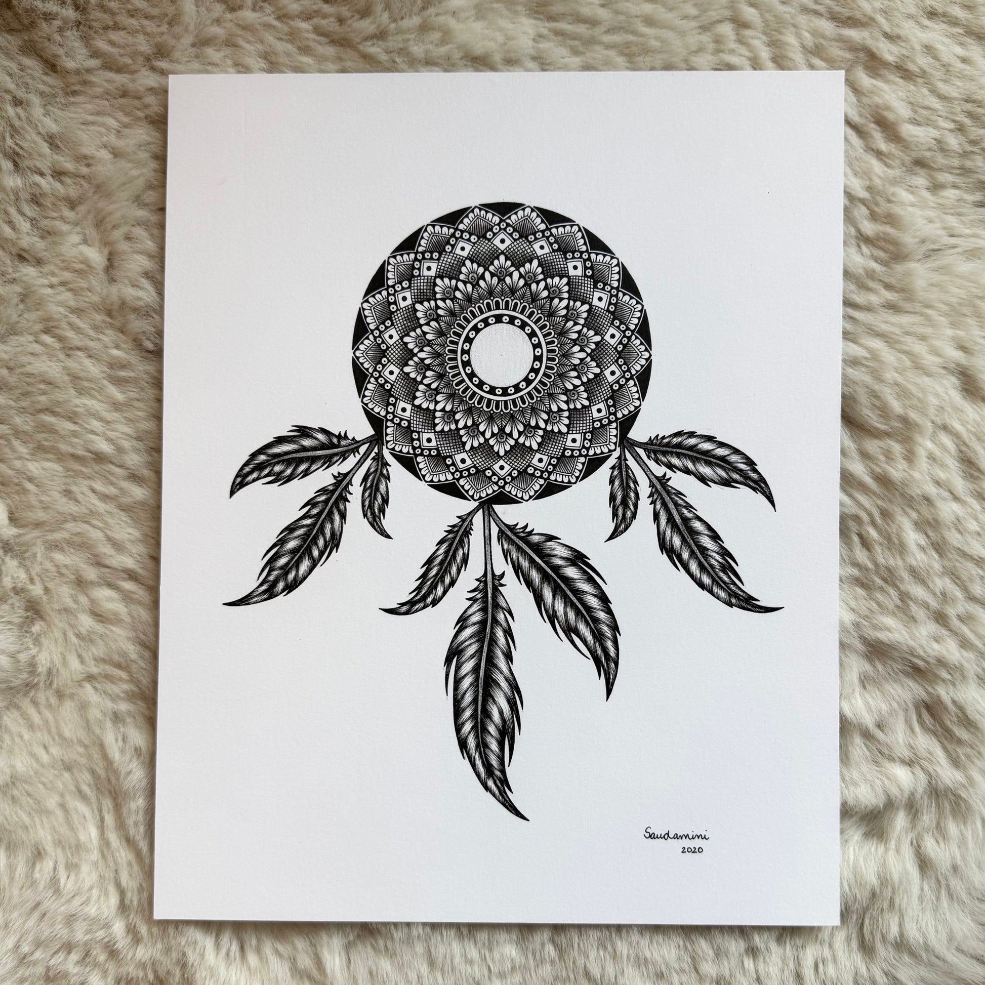Hand-drawn dreamcatcher mandala by Saudamini Madra showing detailed feather rendering in black ink on Bristol paper