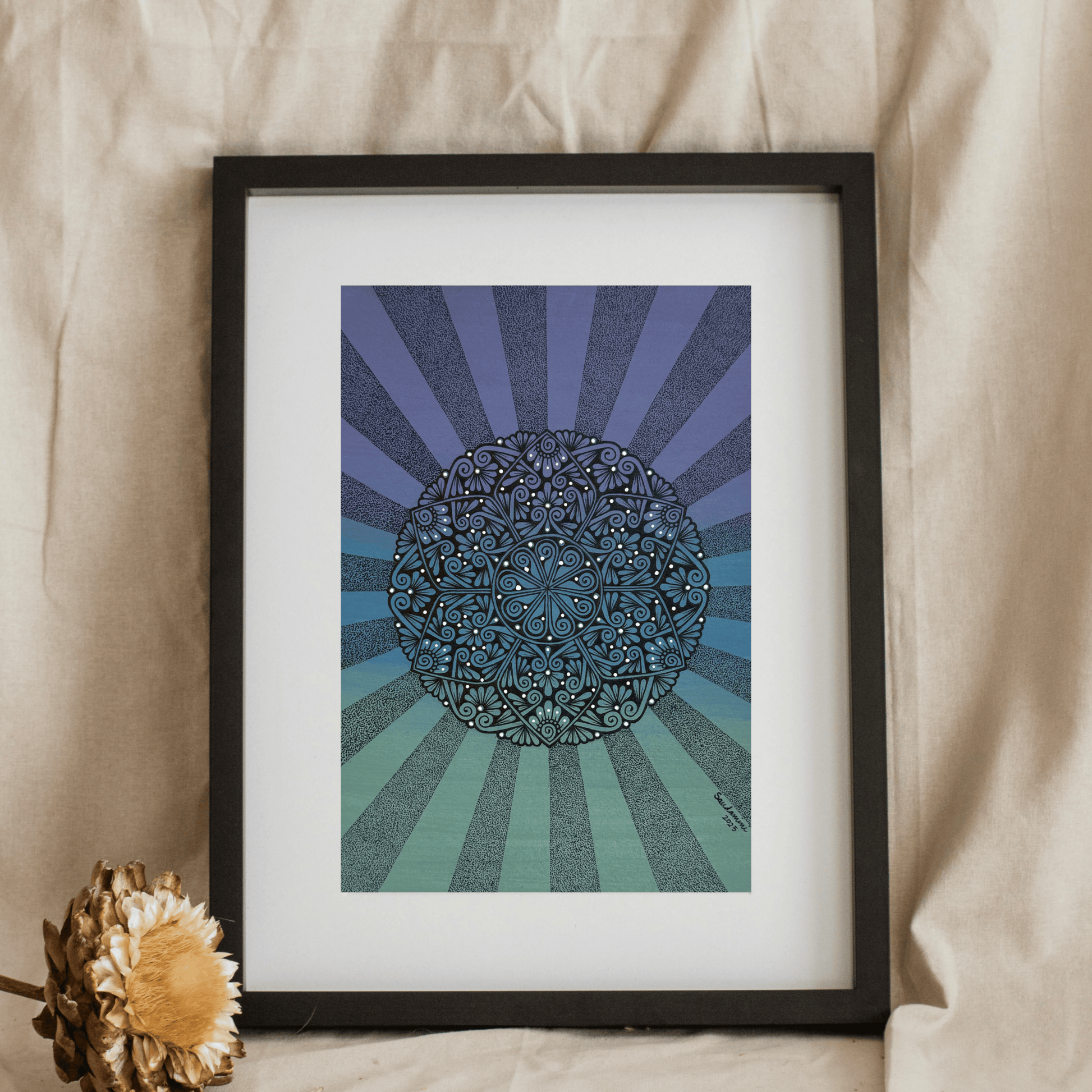 Artwork with a blue and green mandala design on a beige fabric background